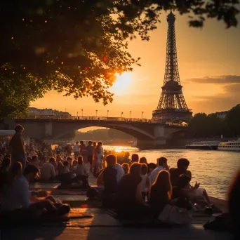 Eiffel Tower at sunset with people having a picnic by the Seine River - Image 2