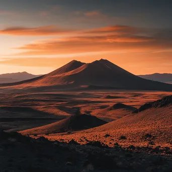 Remote volcano landscape during sunset with vibrant orange sky and shadows - Image 4