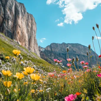 Mountain cliffs adorned with colorful wildflowers under a blue sky. - Image 1