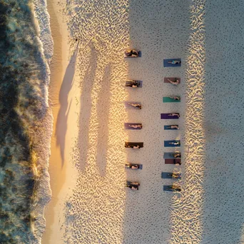 Aerial view of beach yoga session at sunset. - Image 4