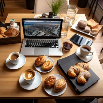 Flat lay of coffee cups, pastries, and work items on a table - Image 3