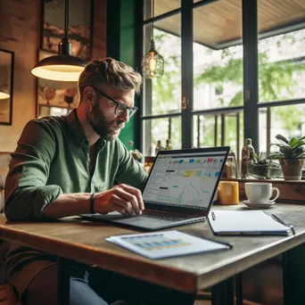 Entrepreneur analyzing market data on a laptop in a coffee shop. - Image 3