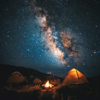 Starry night sky with Milky Way galaxy and campfire on hill - Image 1