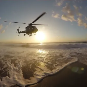 Coastline at sunrise with helicopters patrolling, aerial beach view - Image 3