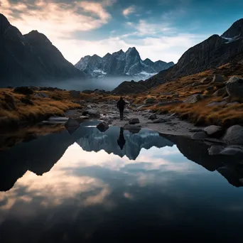 A hiker silhouette in front of a mountain lake - Image 4