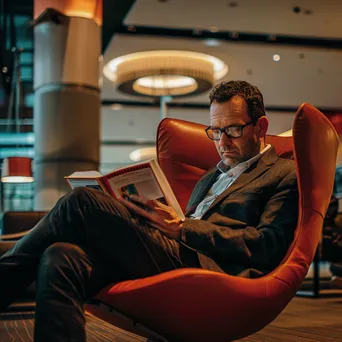 A businessman reading a book in an airport lounge - Image 1