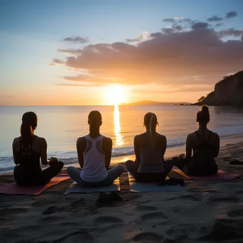 Group of diverse individuals practicing yoga on beach at sunset. - Image 2