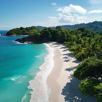 Aerial view of a secluded tropical beach with white sand, clear waters, and surrounding palm trees. - Image 2