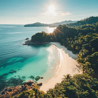 Aerial view of a secluded tropical beach with white sand, clear waters, and surrounding palm trees. - Image 3