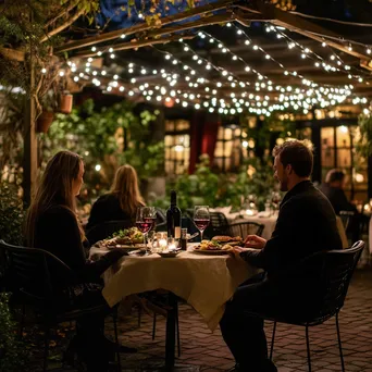 Bistro patio at dusk with fairy lights and couples dining - Image 1