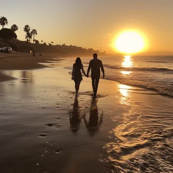 Couple walking along the beach during a vibrant sunset. - Image 3