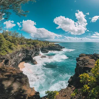 Cliffside view of the beach with dramatic waves and lush greenery under a blue sky. - Image 2