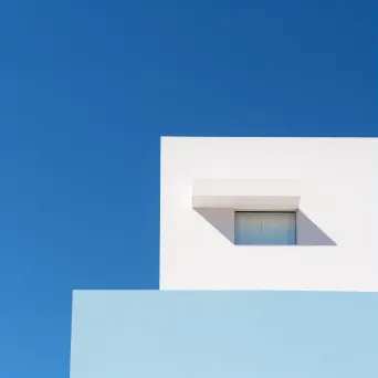 Minimalist building facade against blue sky shot on Sony A7 III - Image 1