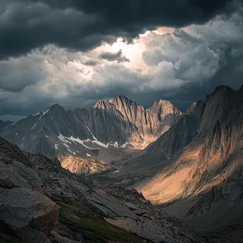 Rocky mountain ridges beneath dark storm clouds - Image 1