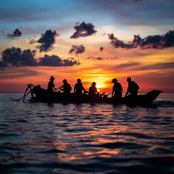 Silhouetted pearl divers against sunset sky - Image 1