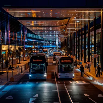 Smart transportation hub with autonomous shuttles and dynamic displays at night - Image 3