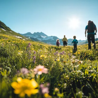 A family hiking through a colorful alpine meadow under clear skies. - Image 3