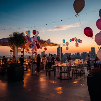 Elegant rooftop birthday party at sunset with balloons and a skyline view. - Image 1