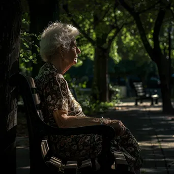 Black and white portrait of an elderly woman sitting on a bench deep in thought - Image 1