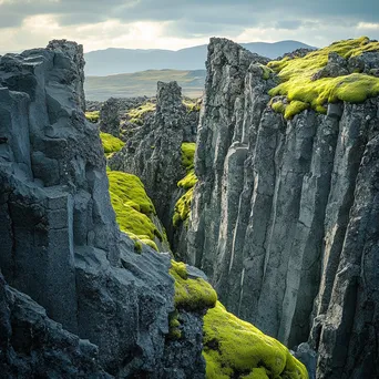 Volcanic landscape showing basalt columns contrasted with green moss - Image 3