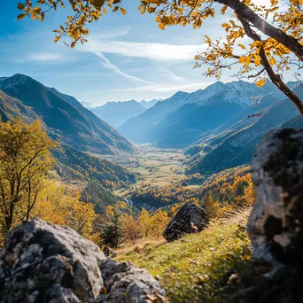 View of a valley rich in autumn colors from a hiking trail under a clear blue sky. - Image 1