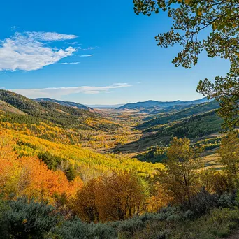 View of a valley rich in autumn colors from a hiking trail under a clear blue sky. - Image 2