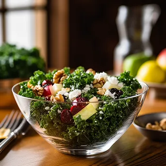 A fresh kale salad with walnuts, cranberries, and feta in a clear bowl on a wooden table. - Image 4