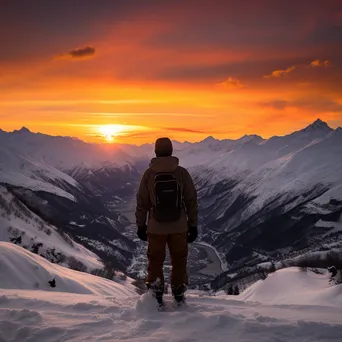 Snowboarder silhouetted against a colorful sunset on the mountain - Image 3