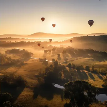 Hot air balloons floating over a green valley during sunset - Image 4