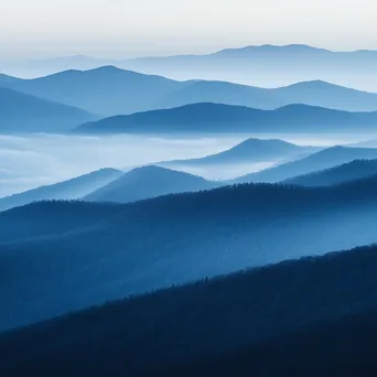 Misty mountain ridges partially obscured by fog - Image 3