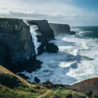 Coastal cliffs overlooking the ocean with crashing waves below - Image 1