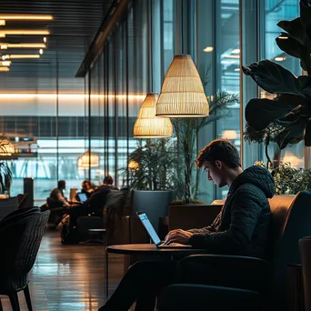 Professional working on laptop in airport lounge. - Image 1