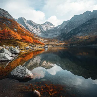 Alpine lake with autumn foliage reflecting in the water - Image 1