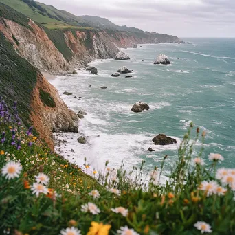 Coastal hiking trail with dramatic cliffs and blooming wildflowers beside crashing waves. - Image 1