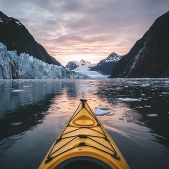 Kayak gliding through icy waters near towering glaciers - Image 1