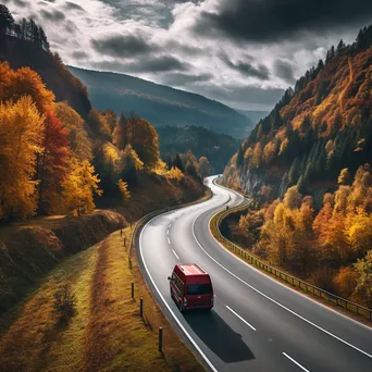 Stylish van parked along a winding road covered in autumn leaves - Image 1