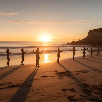 Group practicing yoga on the beach during sunset - Image 3