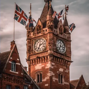 Antique clock tower in town square with flags - Image 2