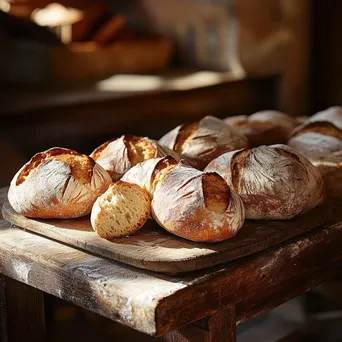 Artisan bread cooling on a wooden board in a cozy kitchen - Image 1