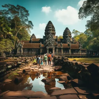 Angkor Wat temple complex in jungle with tourists exploring - Image 1