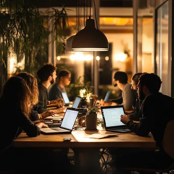 Diverse group in coworking space with laptops collaborating - Image 3