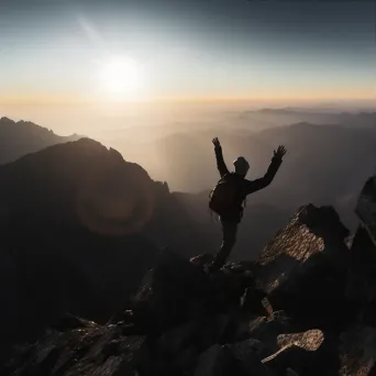 Person reaching a mountaintop with sunrise in the background - Image 3