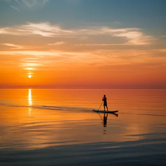 Lone paddleboarder at sunset - Image 2