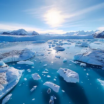 Aerial view of a glacier with icebergs in a serene blue sea - Image 1