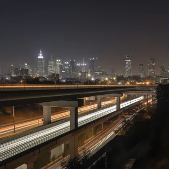 Highway overpass with light trails from passing vehicles and city skyline at night - Image 1