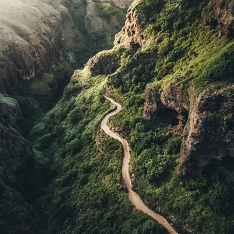 Aerial view of a hiking trail winding through rugged mountainous terrain. - Image 3