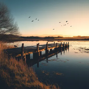 Traditional weir at sunset with calm waters and birds - Image 3