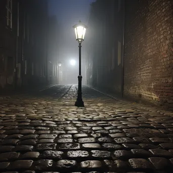 Cobblestone alley illuminated by a street lamp in fog - Image 2