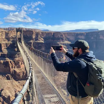 Tourist taking a selfie on a rope bridge over a canyon - Image 4