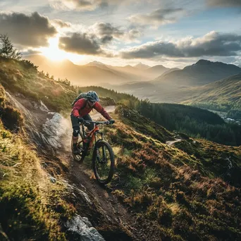 Mountain biker speeding along a narrow trail with scenic views under bright sunlight. - Image 4